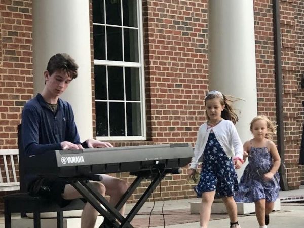 Evan Brezicki’s music entertains not only busy travelers in the main concourse of Charlotte-Douglas International Airport but also tiny fans in front of the Davidson town library.