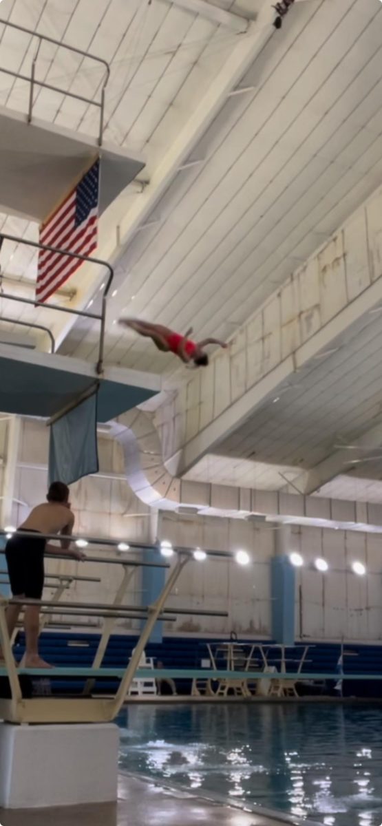 I perform 5231D (Back one and a half summersaults, half twist) off 5 meters. The Carolina Diving Academy flag flies at the Huntersville Family Fitness & Aquatic (HFFA) Center. (Photo taken by Taylor Brantley.)
