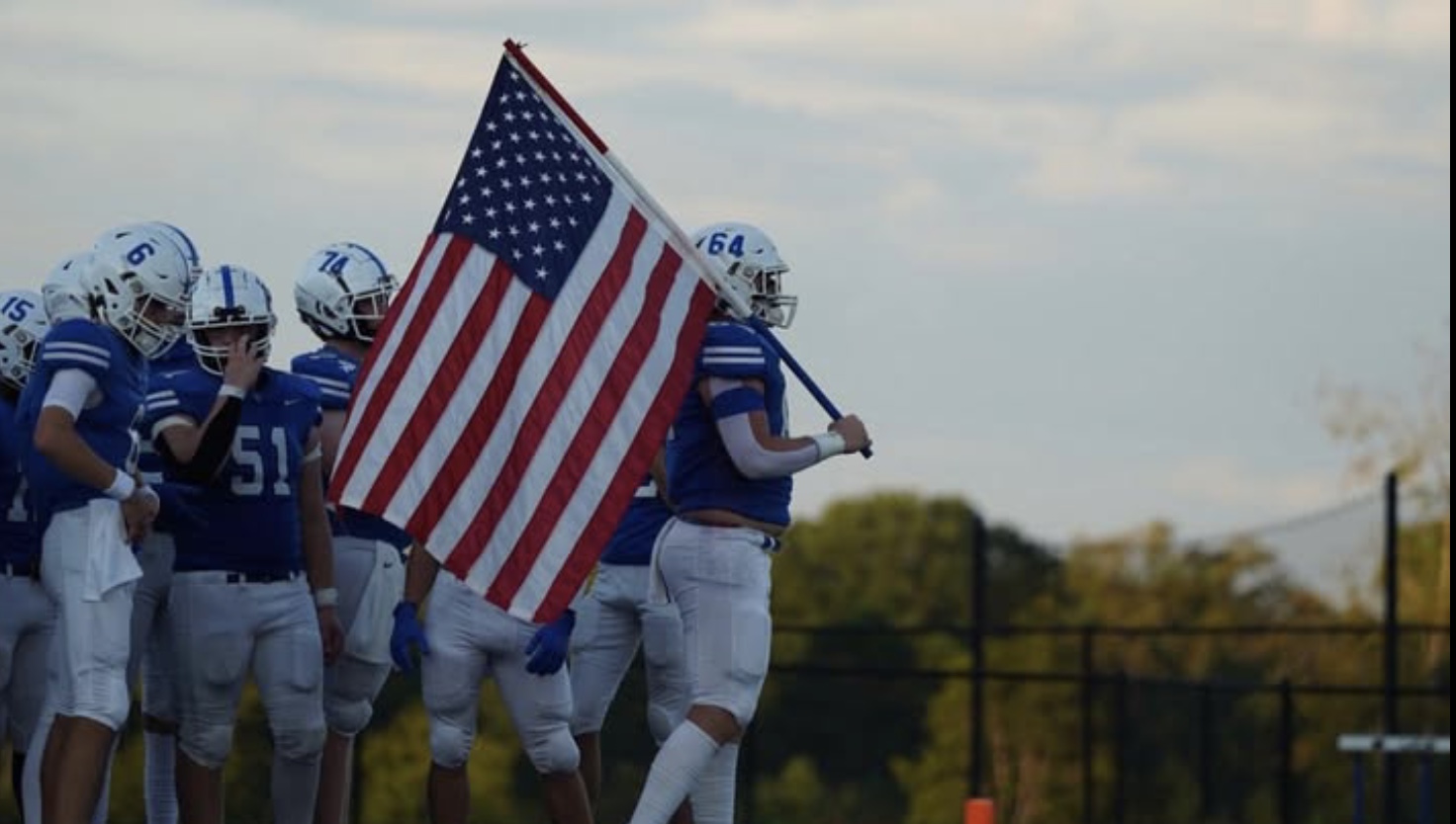 The Community School of Davidson (CSD) Spartans football team begins every game the same way. Before the game, they go out on the field while holding the American flag to show pride for their country and their team. (Photo used courtesy of Mack Sidden ‘25).
