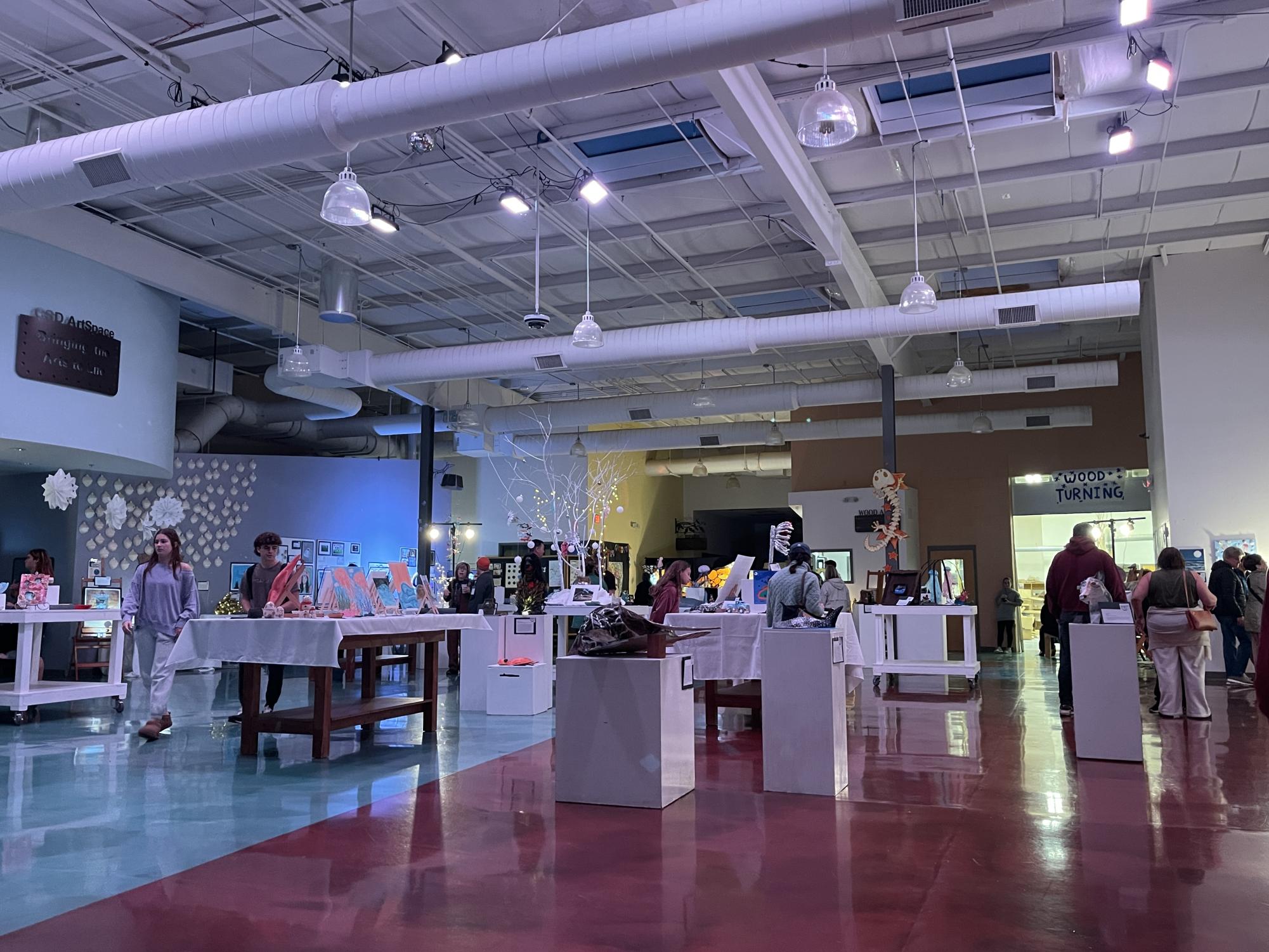 Before doors opened, student artists and staff apply, last-minute organization to the “Under the Sea” gallery. As one of four different areas, The gallery, housed, visual, ceramics, wood and other art during Arts Night ‘24. (CSD Journalism class photo).