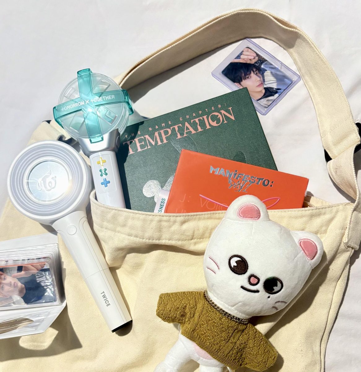 CSD student Isabel McDavitt’s (‘25) collection of K-pop albums and merchandise fill the frame. Some albums displayed are The Name Chapter: Temptation from Tomorrow X Together (TXT) and Manifesto: Day 1 album from ENHYPEN. Merchandise include a mini photocard album, lightsticks from TWICE and TXT respectively, and a Stray Kids’ Victory Hyunjin plush.
