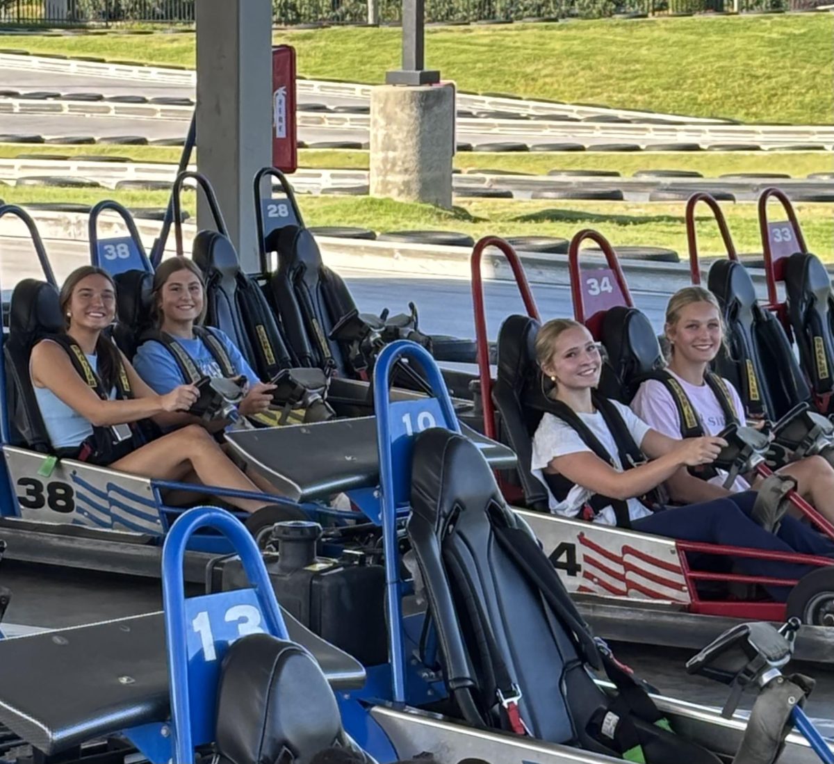 From left: Kennedy Donley (‘26), Gracyn McRorie (‘26), Kelly Rogers (‘27) and Lizzie Shields (‘27) prepare for takeoff on Frankie’s go-cart track. The Association for Applied Sports Psychology says team-building activities and shared experiences can help foster mutual trust and cooperation. (Photo by Coach Betsy Miller)
