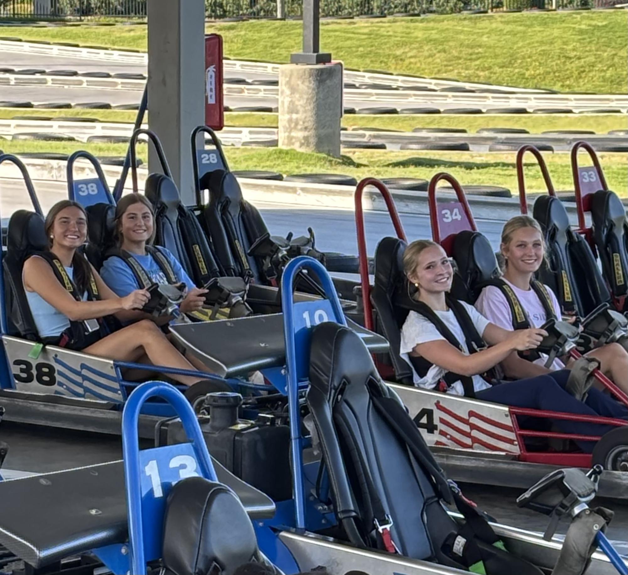 From left: Kennedy Donley (‘26), Gracyn McRorie (‘26), Kelly Rogers (‘27) and Lizzie Shields (‘27) prepare for takeoff on Frankie’s go-cart track. The Association for Applied Sports Psychology says team-building activities and shared experiences can help foster mutual trust and cooperation. (Photo by Coach Betsy Miller)

