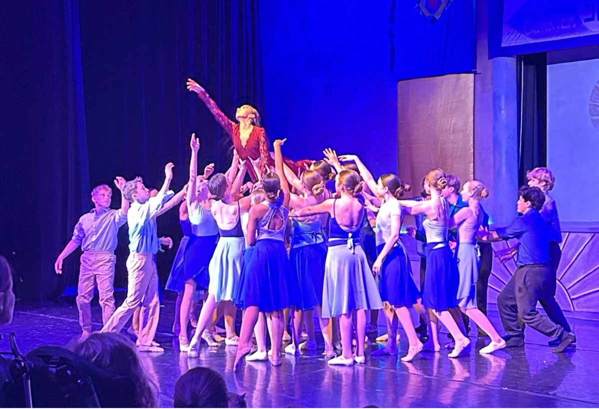 Natalia Modia (‘30), dancing as Lenore Dove, is lifted by students in her “Songbird” cast during a dress rehearsal at noon on Tuesday. The show featured three separate casts, so Modia was one of three Lenores who performed each with a different student in the role of Haymitch, the main character.
